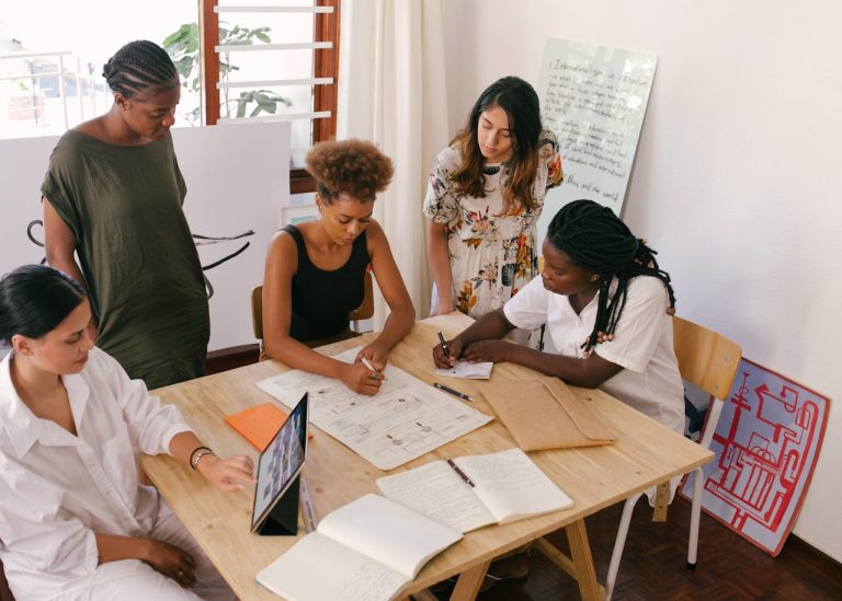 Pessoas reunidas em uma mesa discutindo um projeto educacional.