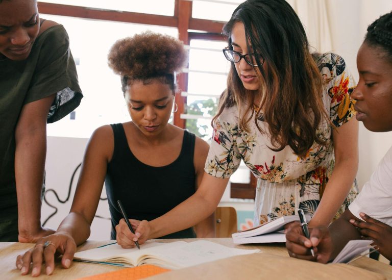 Equipe colaborando em anotações durante uma sessão educacional.